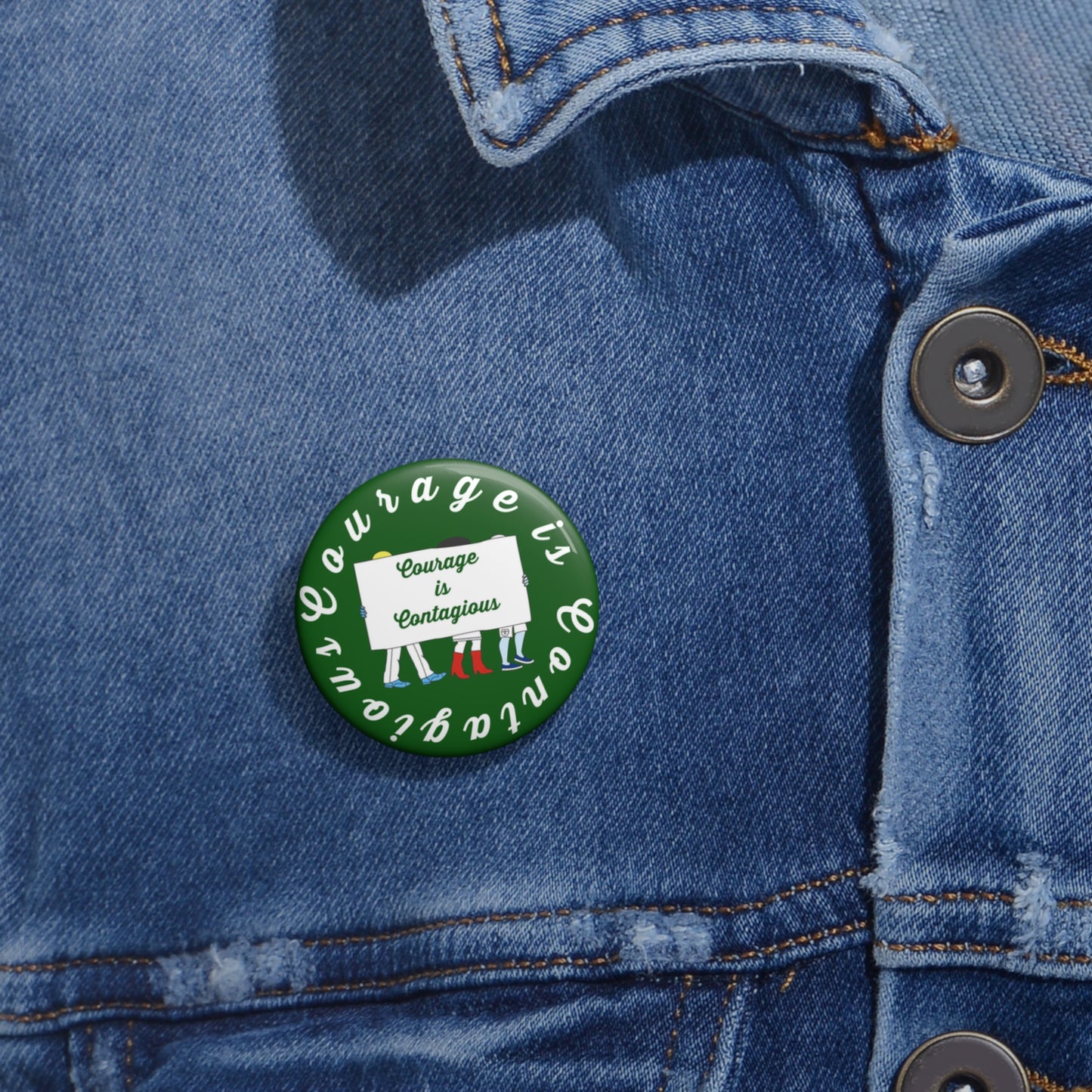Button with 'Courage is Contagious' design on a denim jacket