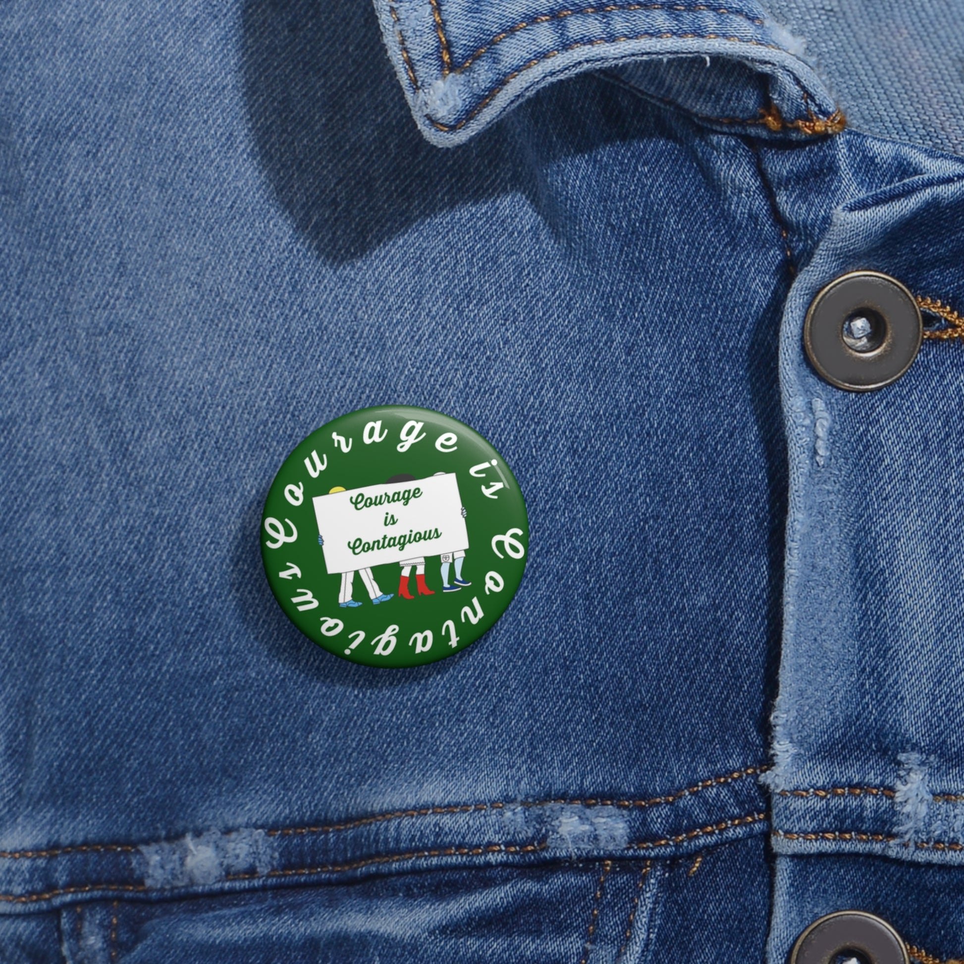 Button with 'Courage is Contagious' design on a denim jacket