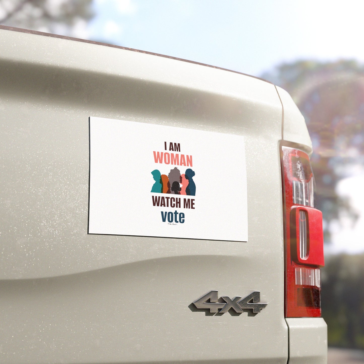 A weatherproof voting women's car magnet on the back of a white 4x4 vehicle reads, "I am woman, watch me vote," accompanied by silhouettes of women in different colors. The bold design stands out like the vibrant Voting Womens Car Magnets by Printify, making a powerful statement.