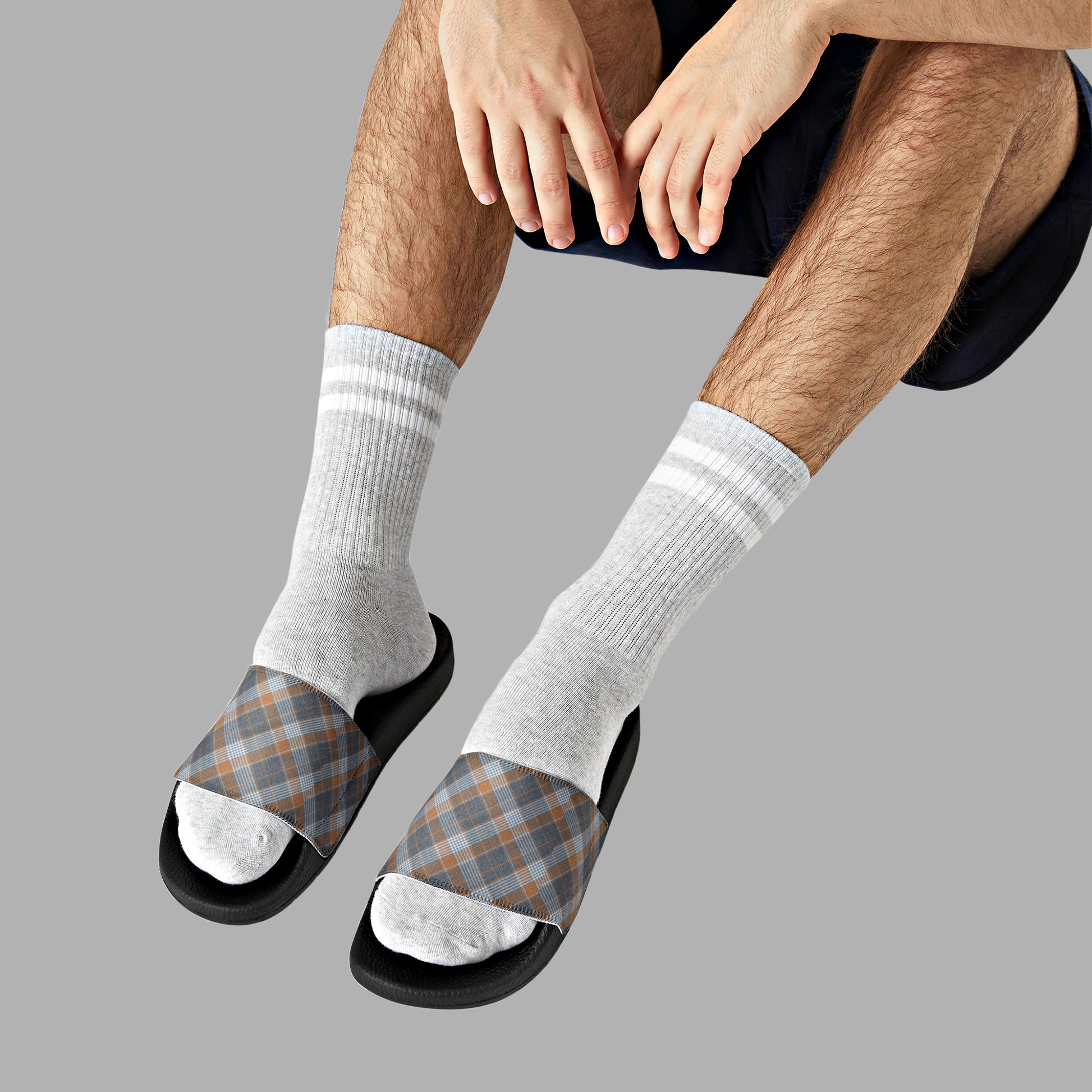 Mock up of a man wearing white socks and our Grey-Plaid sandals