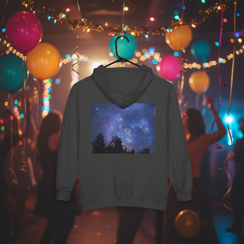 The Printify Galaxy Night-Sky Zip Hoodie (Unisex, back print) with a galaxy and tree design is displayed on a hanger against a festive backdrop of balloons and string lights.