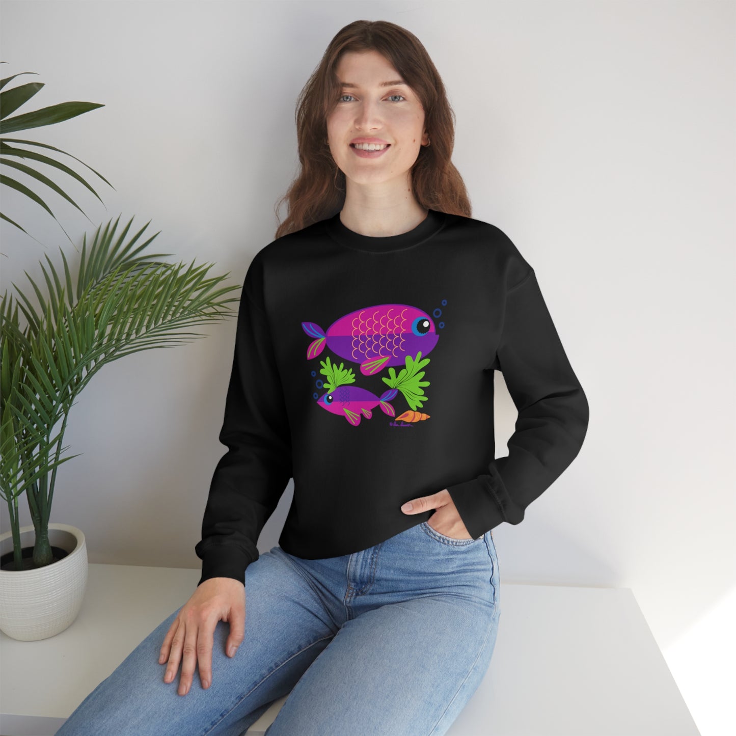 Mock up of a woman sitting on a surface while wearing the Black shirt