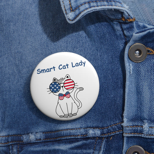 A whimsical accessory, this lightweight and durable Printify Unisex Smart Cat-Lady Button features a charming illustration of a cat sporting American flag sunglasses along with the text "Smart Cat Lady," making it perfect for pinning to a denim jacket. Available in two sizes.