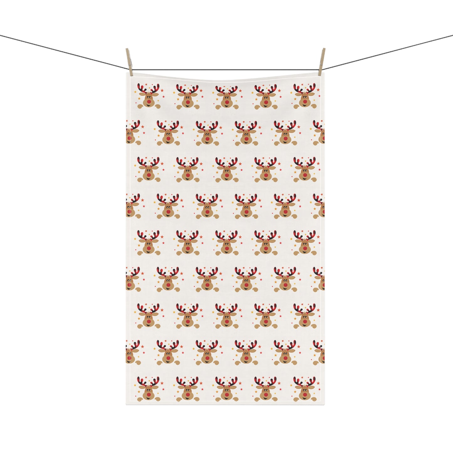 A Festive Reindeer Tea Towel from Printify, featuring a repeating pattern of joyful holiday reindeer faces, hangs beautifully on a clothesline, embodying the festive spirit.