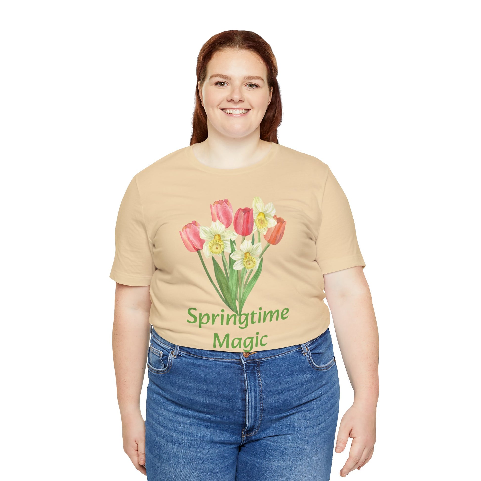 Woman in a beige Unisex Springtime-Magic T-shirt by Bella + Canvas, paired with blue jeans, smiling at the camera.