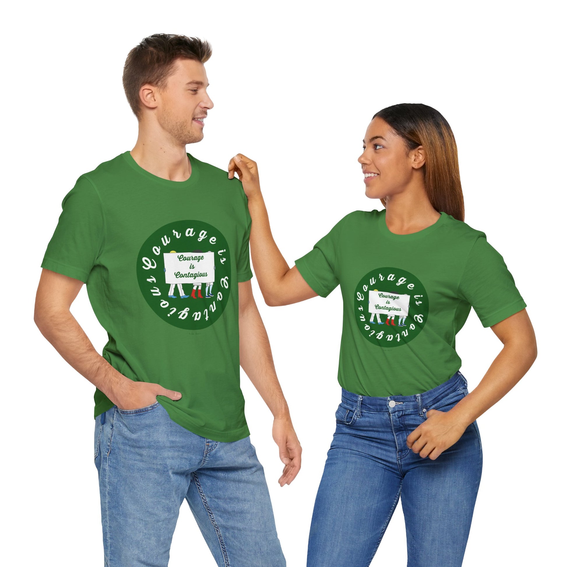 Two people wearing Printify's "Courage Is Contagious T-shirt: Unisex | Activist Graphics" in green, featuring the text "Courage in vulnerability," stand and smile at each other, spreading an inspiring message through these lightweight cotton tees.