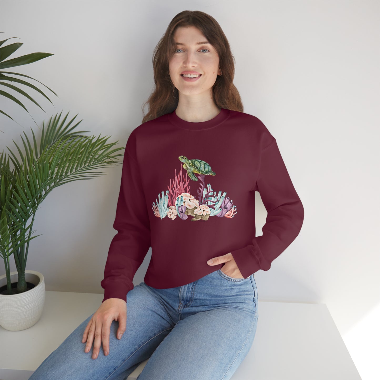 Mock up of a woman sitting on a surface while wearing our Maroon shirt