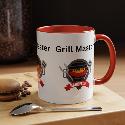 A Printify Grill Master Mug: Unisex; 11 oz; Ceramic; Graphics; Accented with a white and red "Grill Master" design stands proudly on a wooden surface, accompanied by a spoon, a macaron, and coffee beans. This American-made piece is perfect for any barbecue enthusiast.