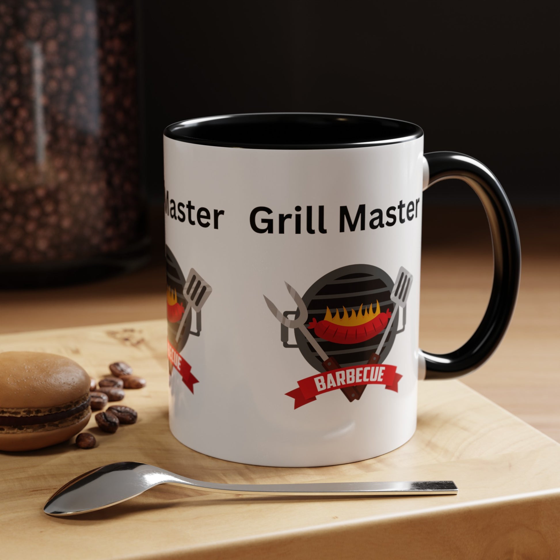 A custom "Grill Master Mug: Unisex; 11 oz; Ceramic; Graphics; Accented", proudly American made by Printify, showcasing a logo with grilling utensils and a BBQ design. This Grill Master Mug: Unisex; 11 oz; Ceramic; Graphics; Accented is placed on a wooden surface alongside a spoon, a macaron, and some coffee beans for the perfect scene.