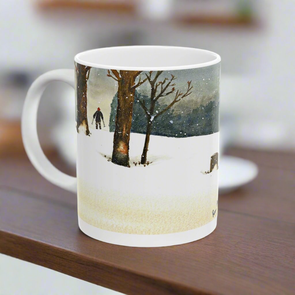 Embrace the allure of the Winter Wonderland Mug by Printify. This 11 oz. ceramic mug displays a tranquil winter scene in watercolor art, depicting a person walking through snowy paths alongside bare trees under a starry night sky.