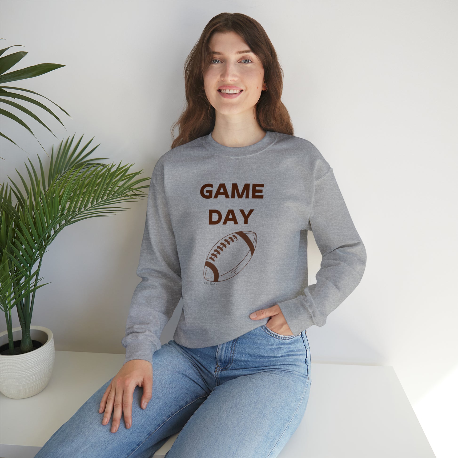 Mock up of a woman who is sitting on a surface while wearing our sweatshirt
