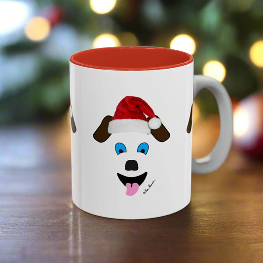 A Printify Festive Dog-Face Coffee-Mug rests on a wooden table, featuring a cheerful cartoon Santa Dog. The blurry festive lights in the background enhance its charm—an ideal ceramic gift idea for dog lovers this holiday season, available in 2 sizes.