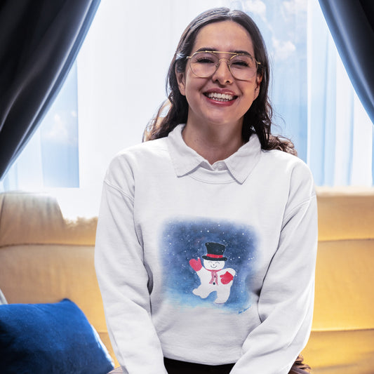 A woman with glasses smiles on a sofa, wearing Printify's Snowman Holiday Crewneck Sweatshirt: Cute Winter Design, featuring a snowman in a top hat, red scarf, and mittens.