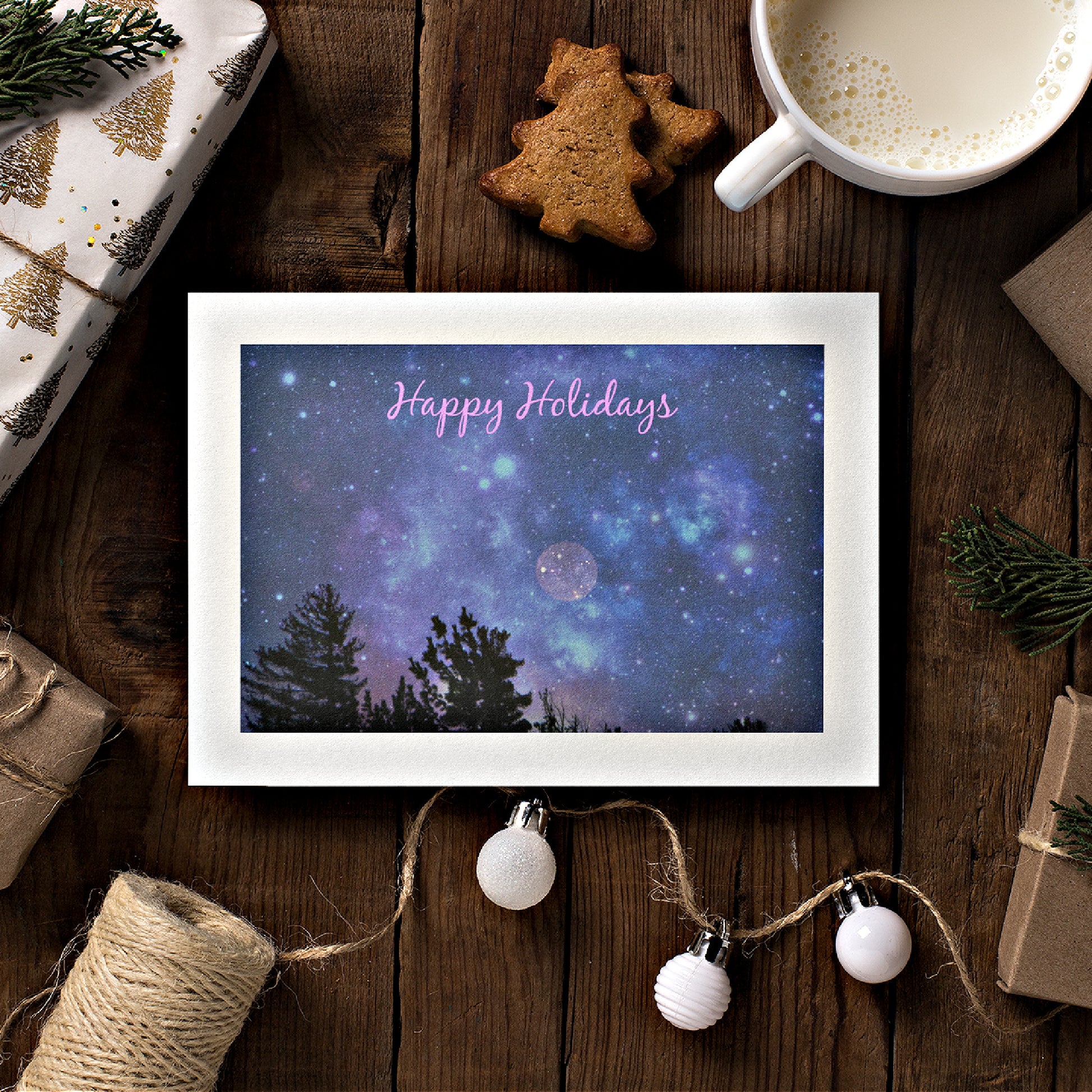 A mock up of our Happy Holidays Card featuring a full moon in a night sky and pink text