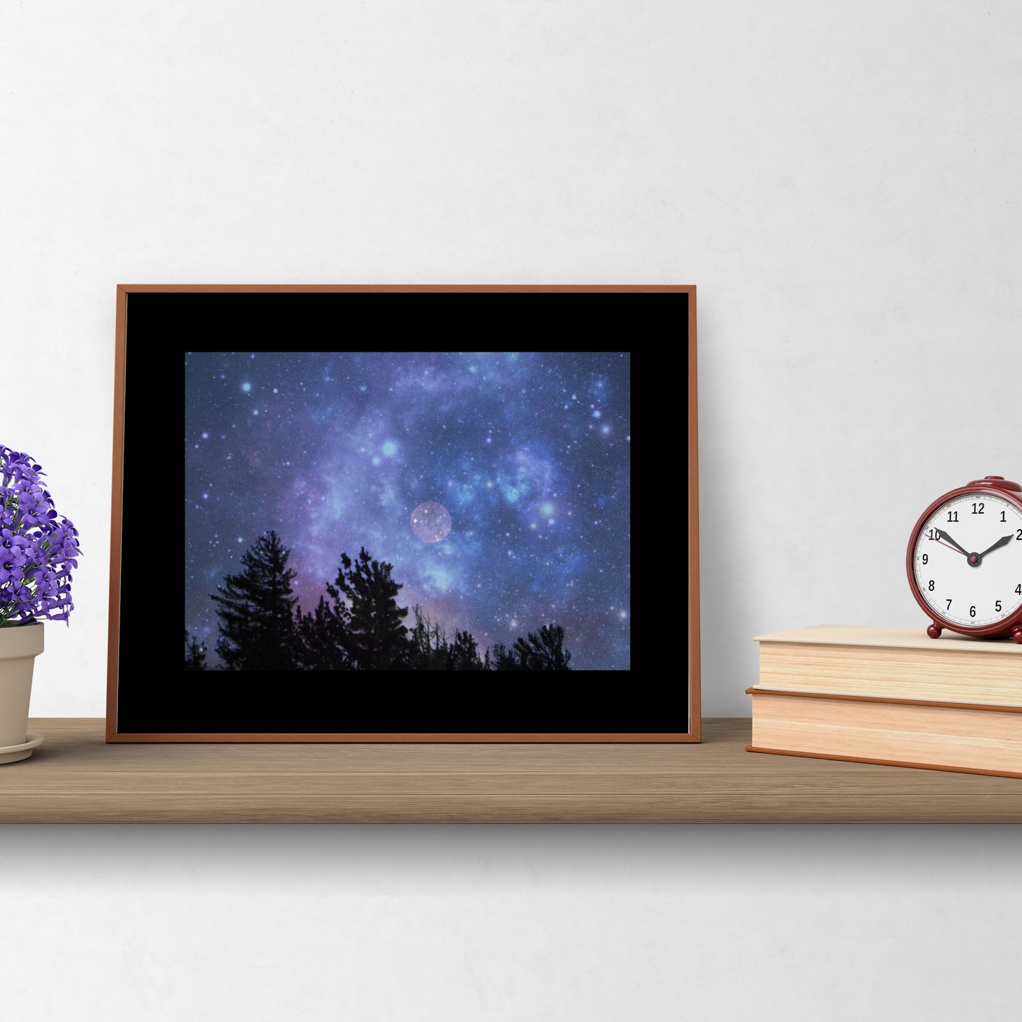 Mock up of Blue-Moon Wall Art as seen on a shelf next to a pot of flowers and a stack of books with a clock on top.