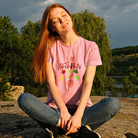 Mock-up of a Woman wearing our relaxed-fit Love-Autumn T-shirt in color pink as she is outside enjoying nature