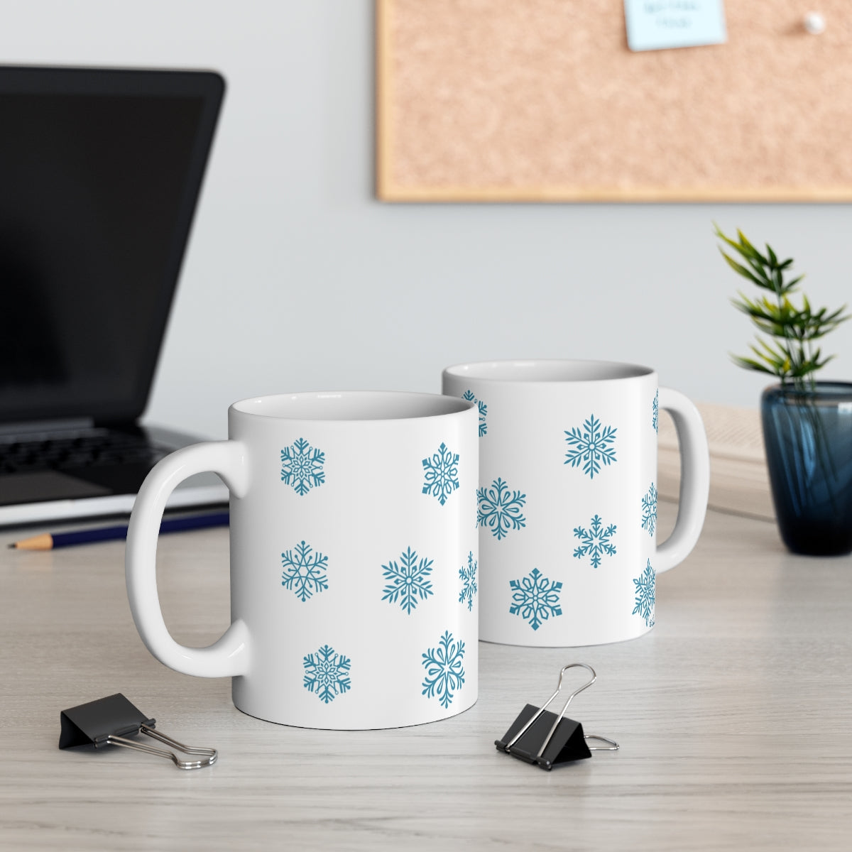 Mock up of 2 mugs on a surface with a laptop computer in the background