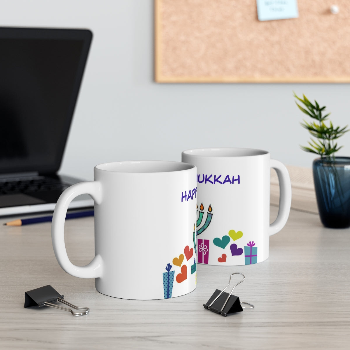 Mock up of 2 mugs on a surface with a lap top computer in the background