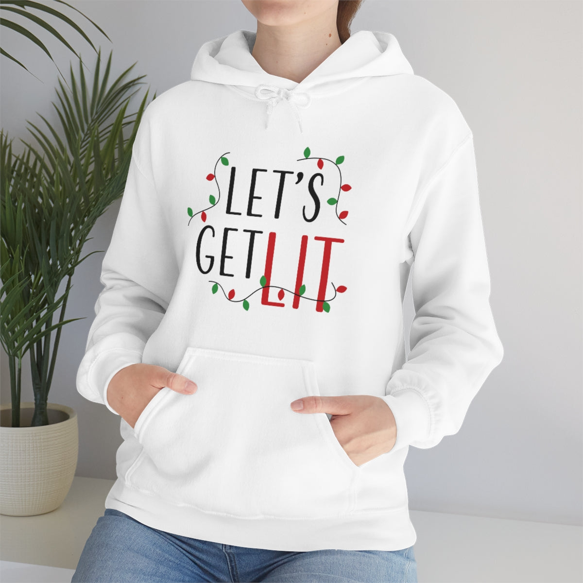 Mock up of a woman wearing our White Holiday Pullover Hoodie while sitting on a bench