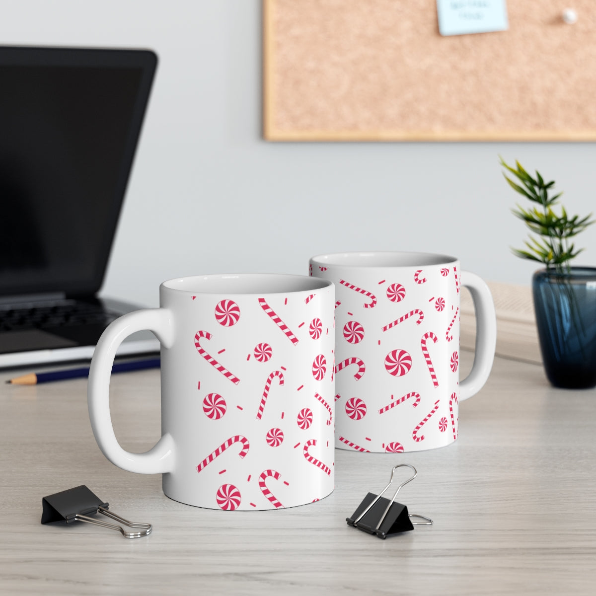 Mock up of 2 mugs on a surface with a computer laptop in the distance