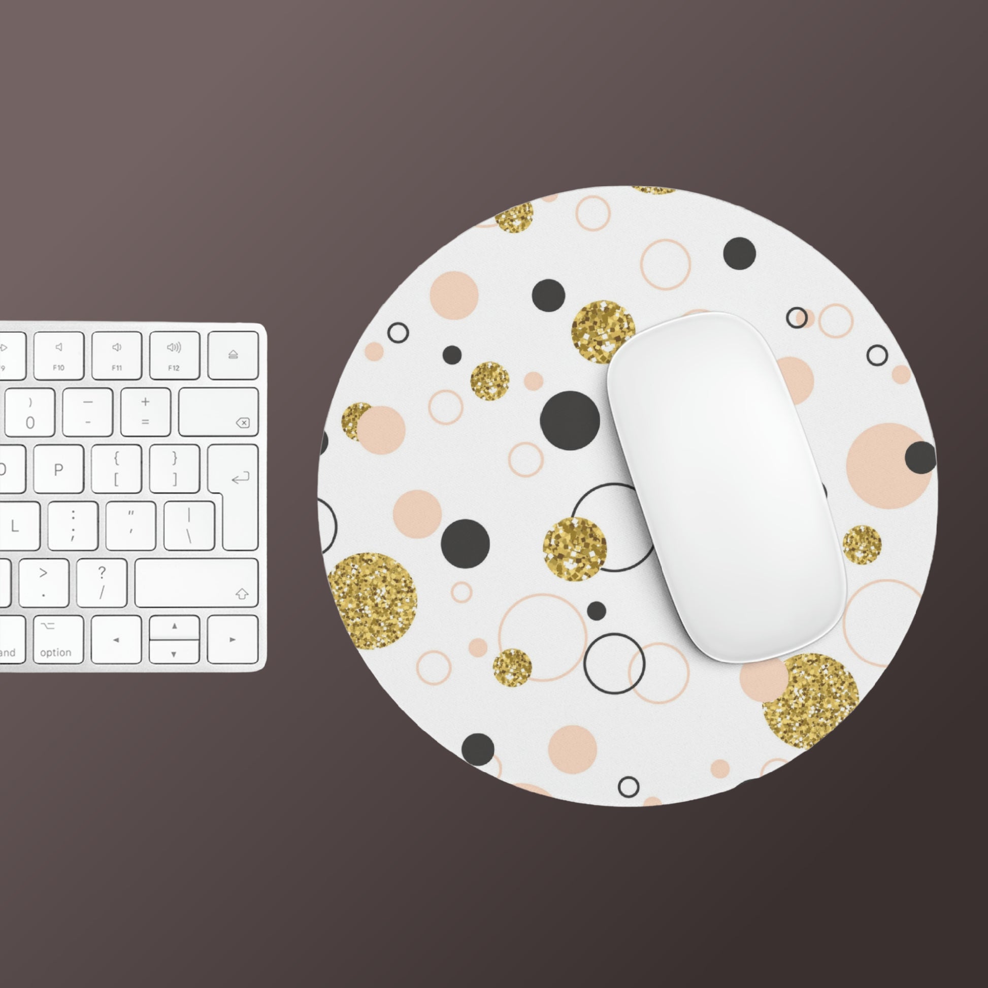 A white keyboard and a round mousepad with a white mouse on top. The Round Mouse Pad: Retro design; 1/4" thick; Circles & Dots by Printify, crafted from neoprene construction, features a pattern of gold glitter, pink, and black dots against a white background. It also has a non-slip rubber bottom for added stability.