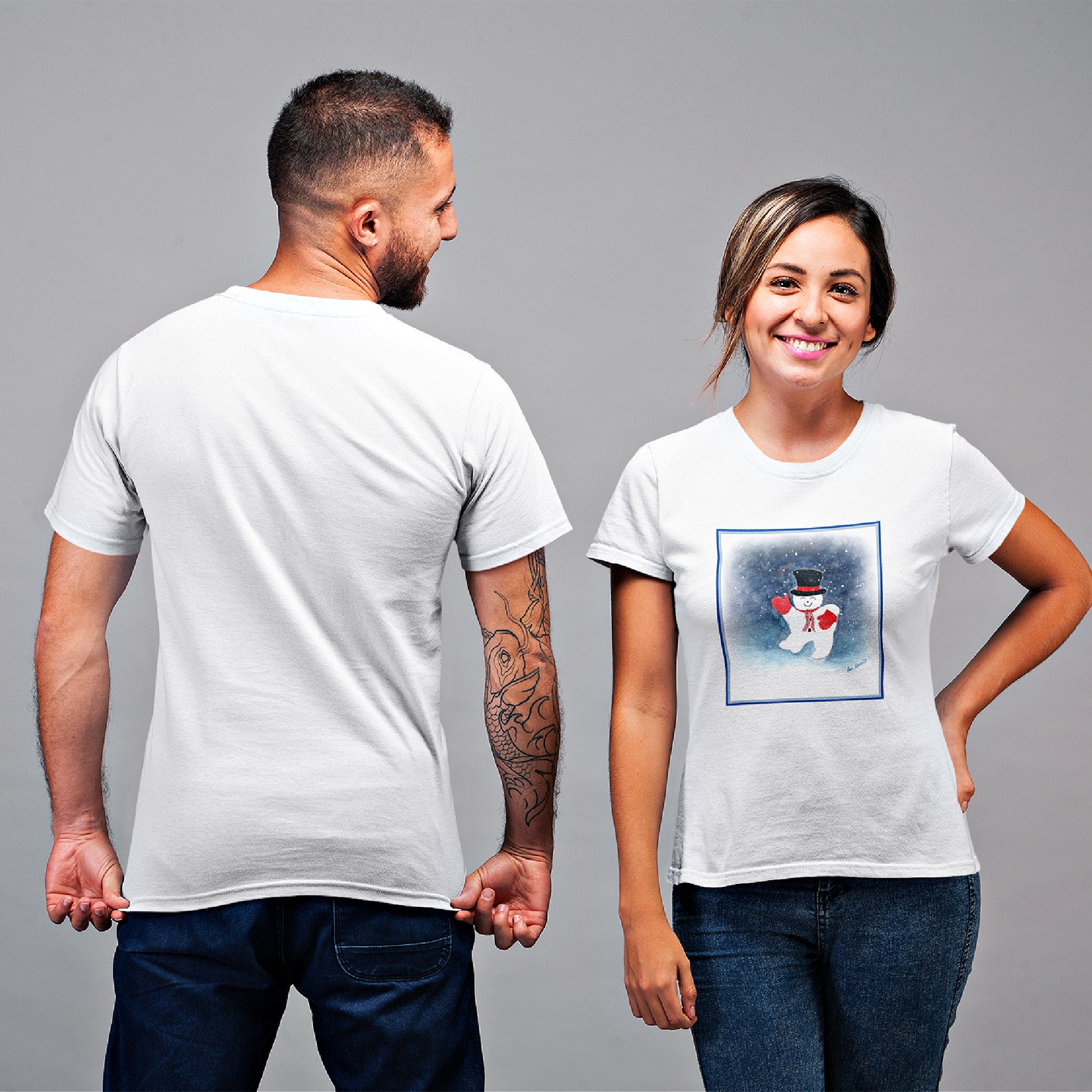 Mock up of a woman wearing our White Snowman T-shirt standing next to a man whose back is facing the camera