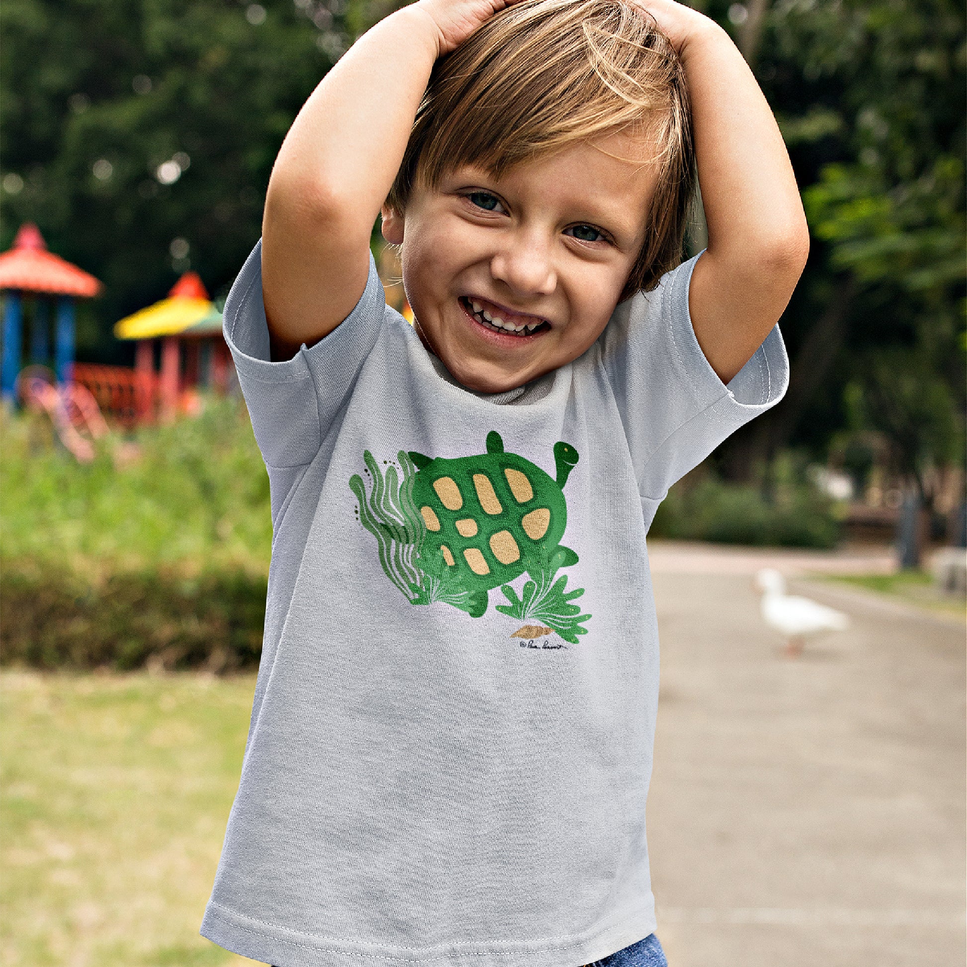 Mock up of a smiling boy wearing our Ash Gray t-shirt