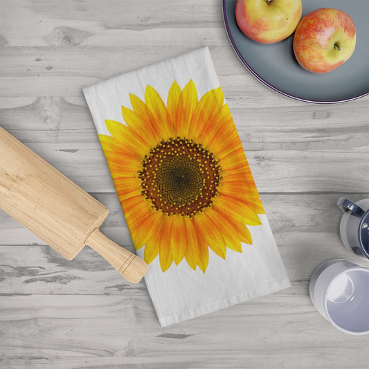 Life-style photo of our Sunflower Kitchen Towel  folded on a surface next to a rolling pin and 2 apples