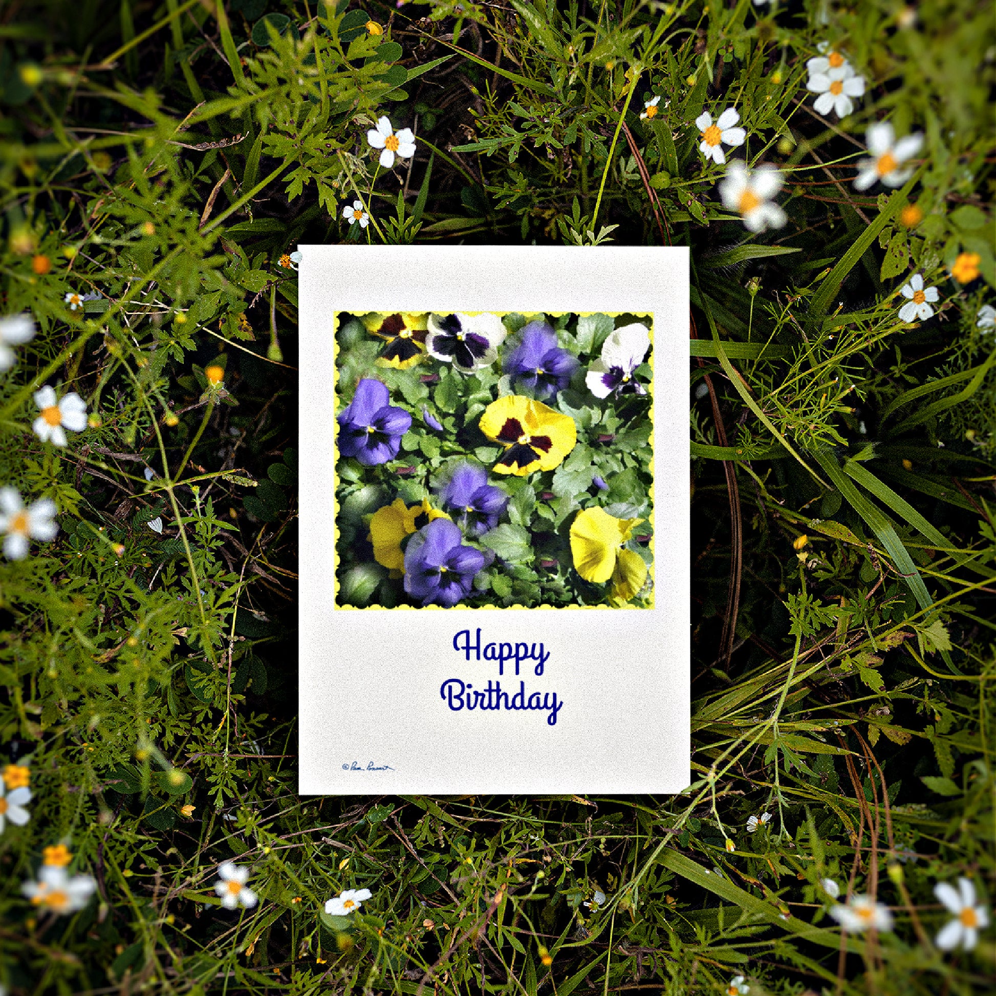 Mock up of one of our Pansy-Photo Greeting Cards laying on a background of flowers
