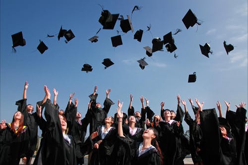 Happy graduates tossing their hats into the air