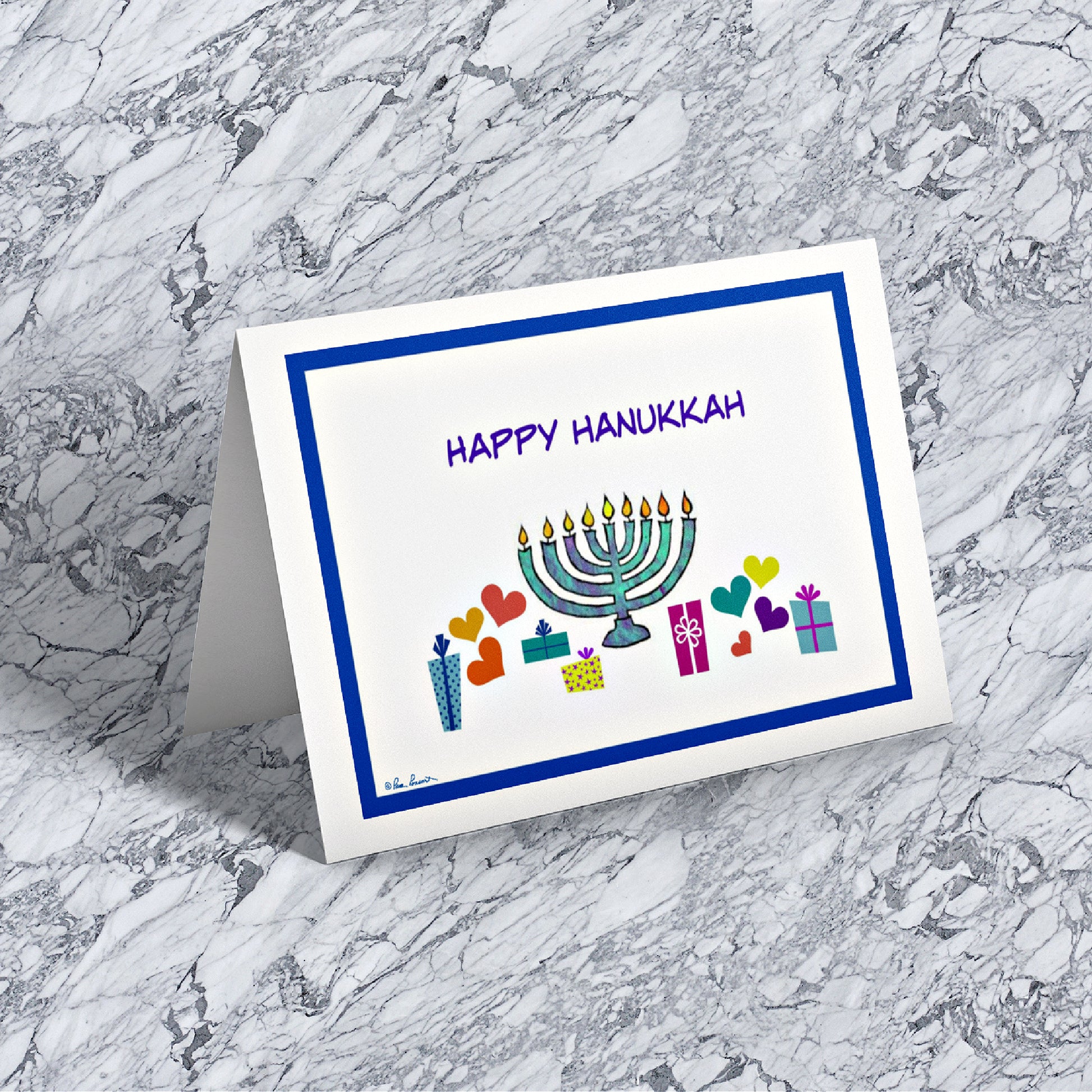 Mock up of our Hanukkah Celebration Card on a marble surface
