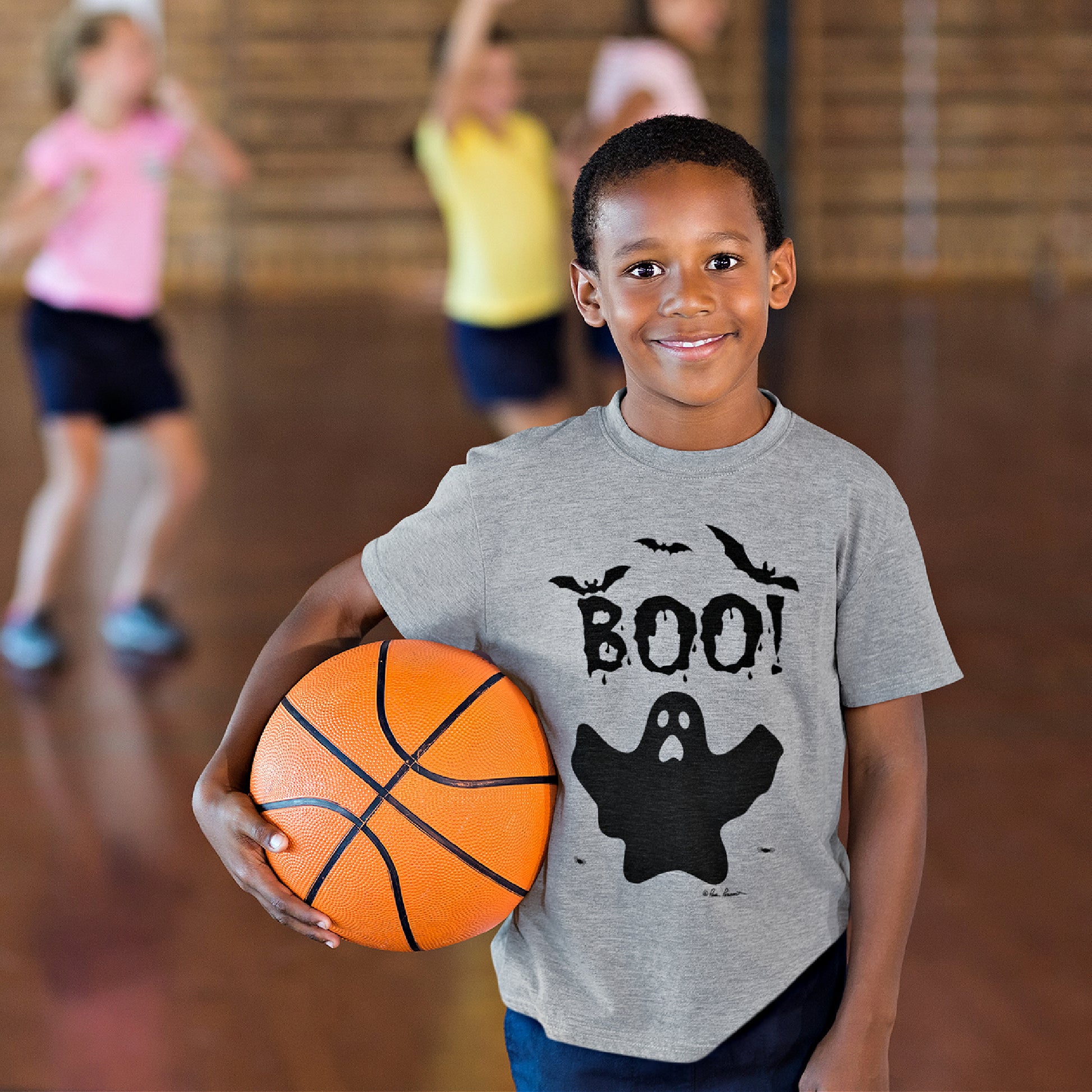 Cute little boy wearing our Kids Fall-O-Ween T-shirt and holding a basketball