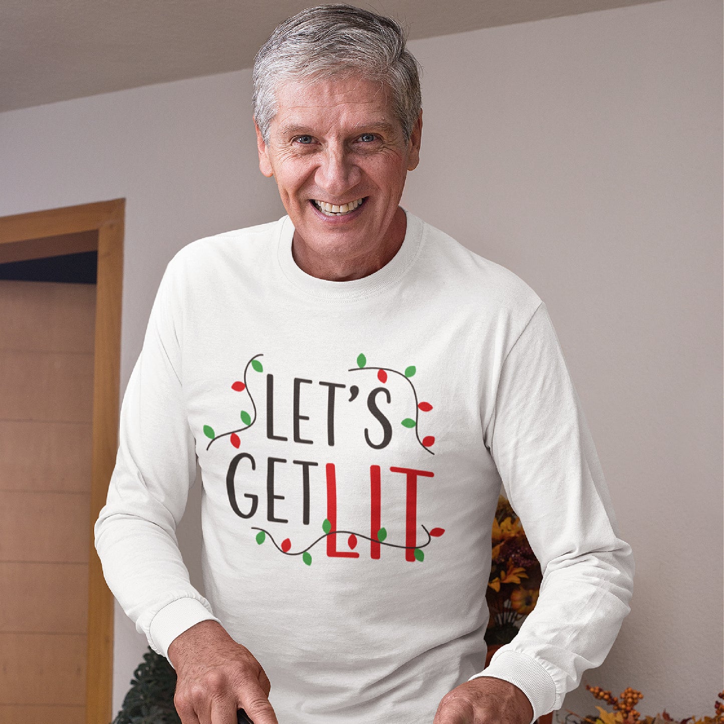 Mock up of a man happily getting ready for a meal while wearing our long-sleeve Unisex Holiday T-shirt