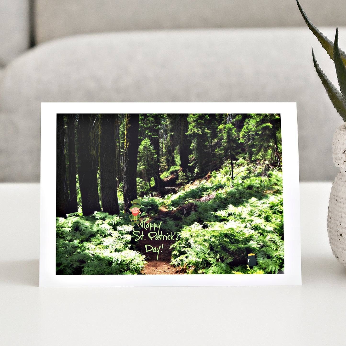 Mock up of our Lucky-Leprechaun Greeting Card on a table next to a plant