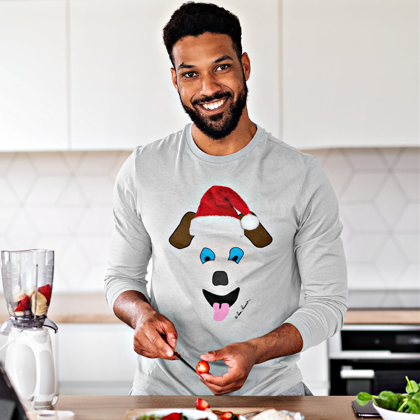 Mock up of a happy man slicing strawberries in the kitchen while wearing our Ash Grey t-shirt