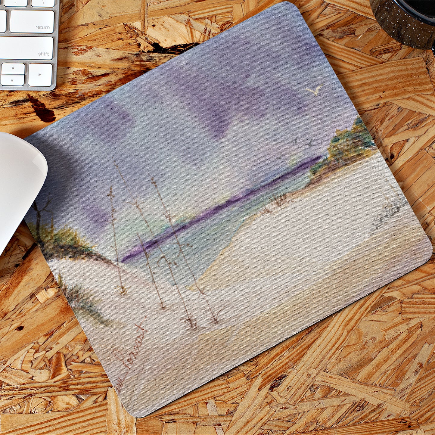 Mock up of our Watercolor-Art Mouse Pad lying on a wooden surface