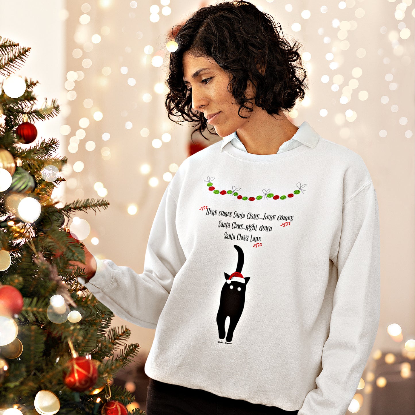 Mock up of a Woman standing by a Christmas tree while wearing our white sweatshirt