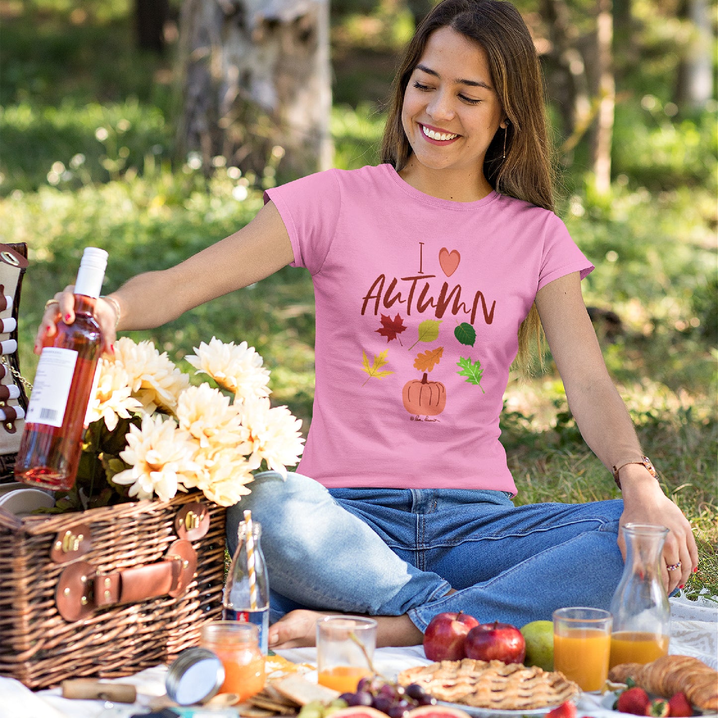 Mock up of a smiling woman on a picnic wearing our slim-fit pink Autumn Love  T-shirt for Women