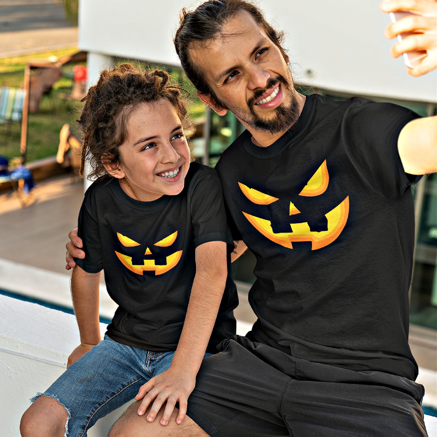 Mock up of a child wearing our Kids Halloween T-shirt together with his Dad who is wearing a matching T-shirt