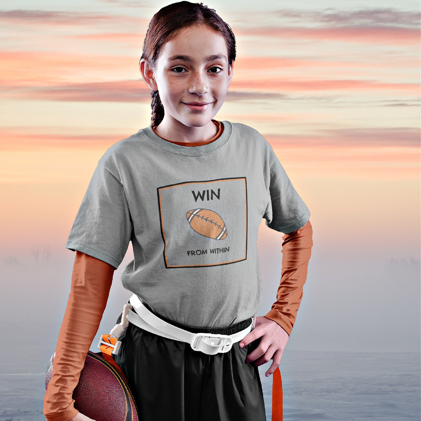 Mock up of a happy girl holding a football and wearing our T-shirt