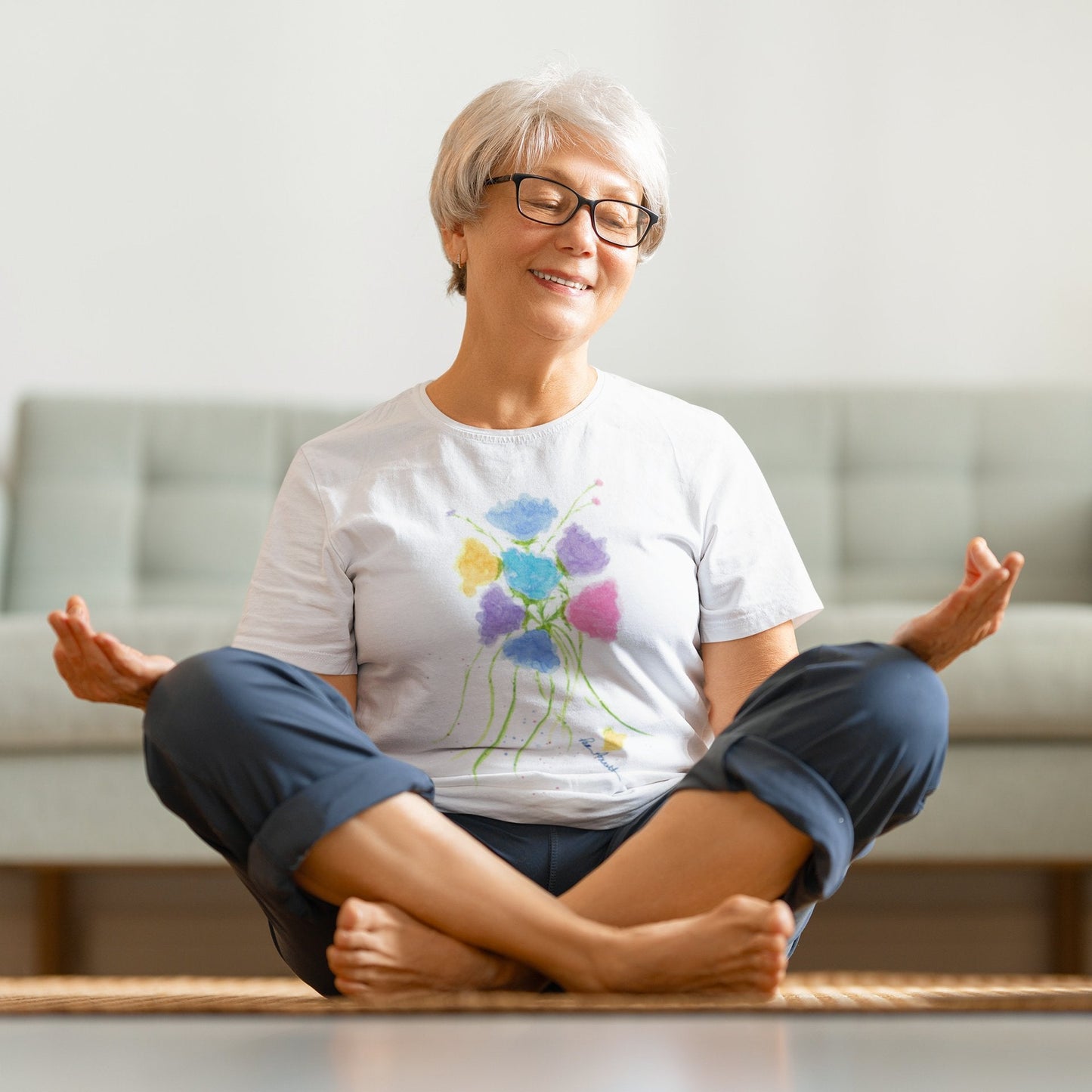 Woman meditating while wearing our white Watercolor Flowers T-shirt